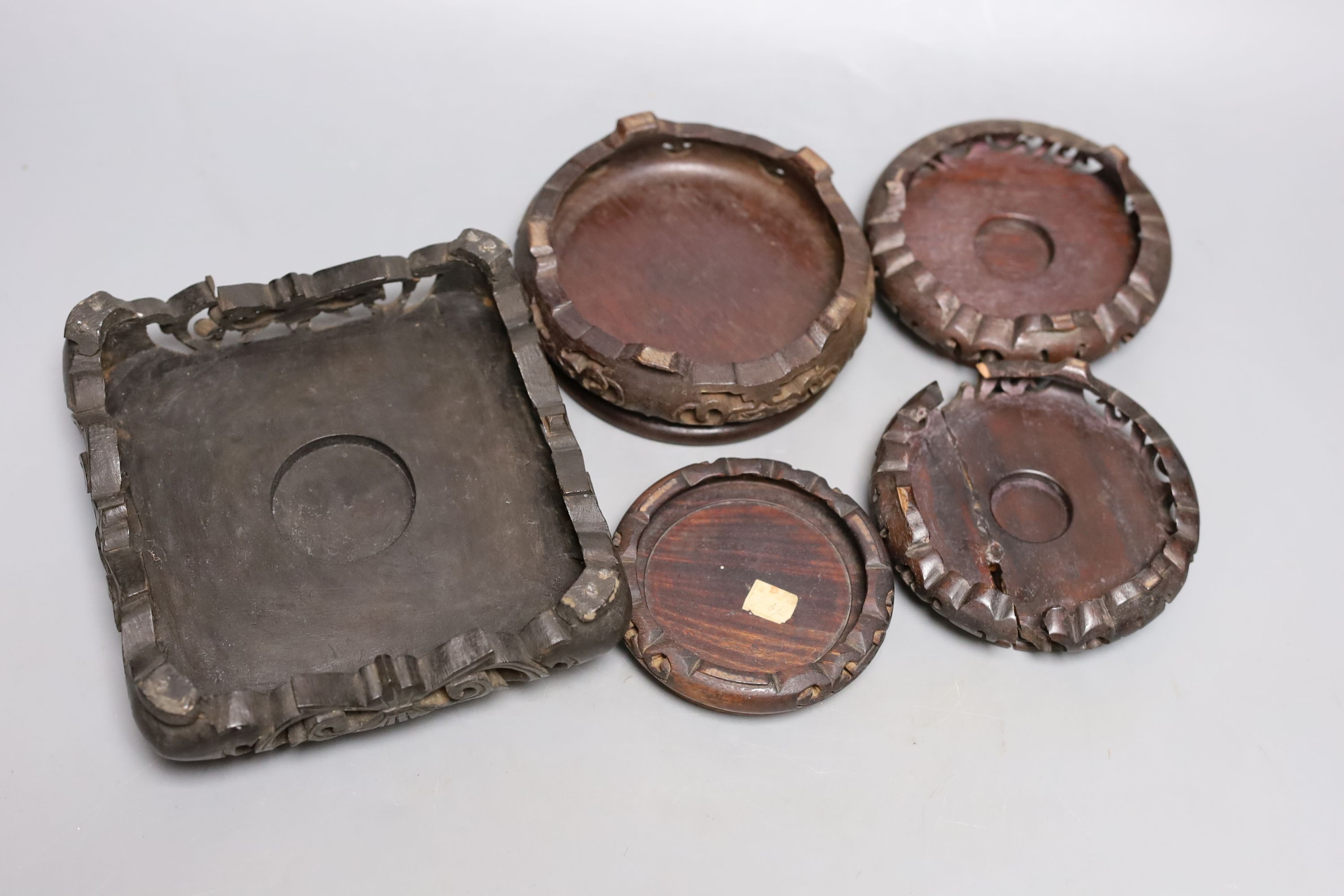 Five Chinese carved hardwood stands, largest 15cm.